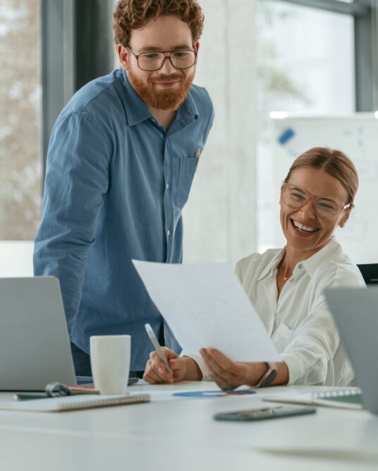 group-young-business-people-discussing-something-smiling-while-sitting-office-table 1